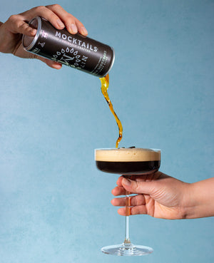 Nitro Espress0% Martini mocktail being poured into a coupe glass with rich foam on top.