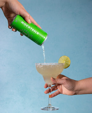 Mockarita mocktail poured into a salted margarita glass with a lime wheel garnish.