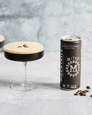 Nitro Mocktails Espress0% Martini can next to an espresso martini in a coupe glass.